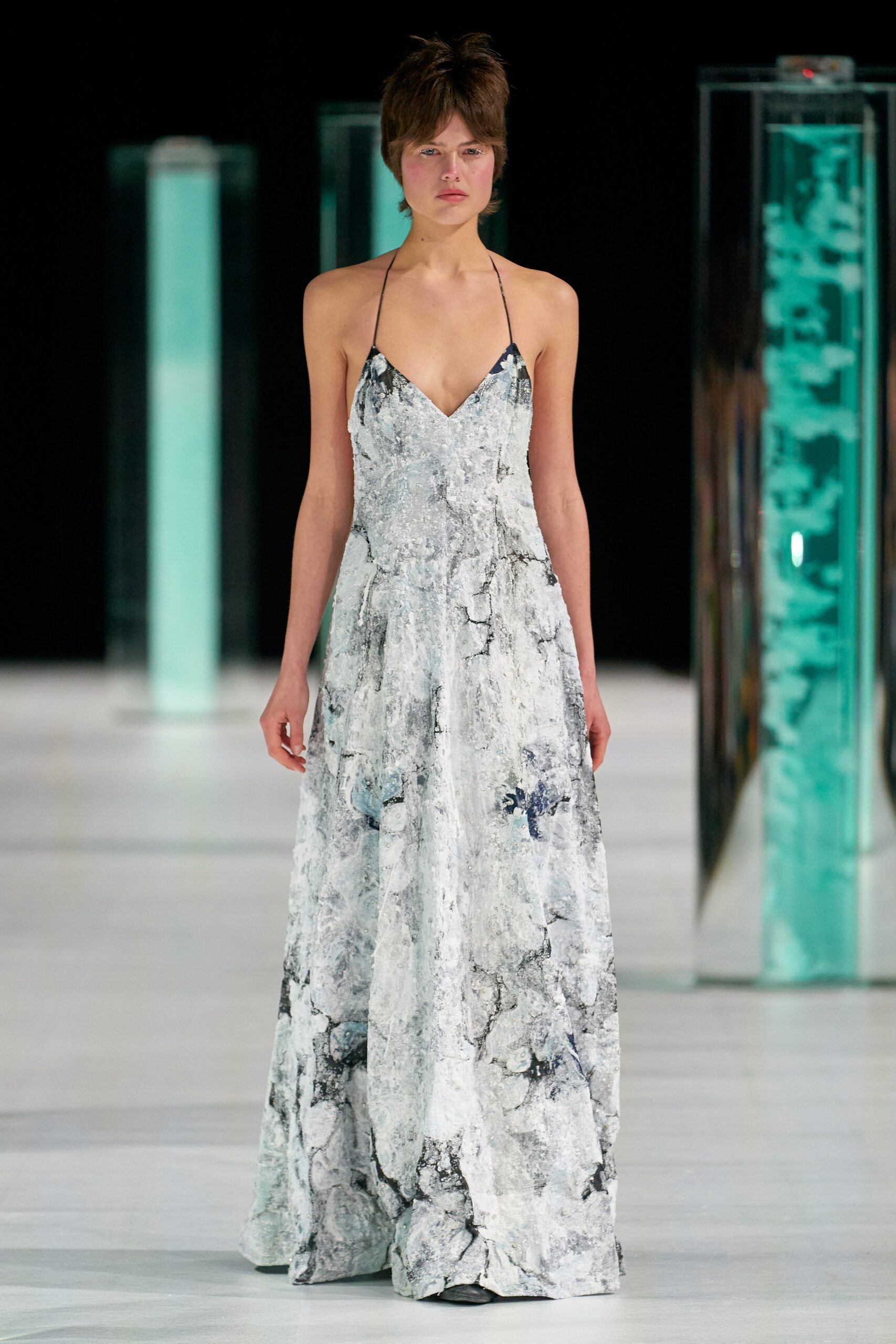 A fitted white and gray silk sleeveless dress with a V-neckline and maxi silhouette.