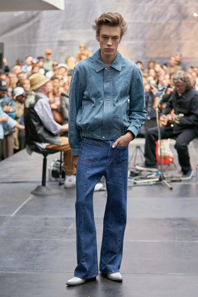 A relaxed blue denim jacket with long sleeves paired with straight-leg denim pants.
