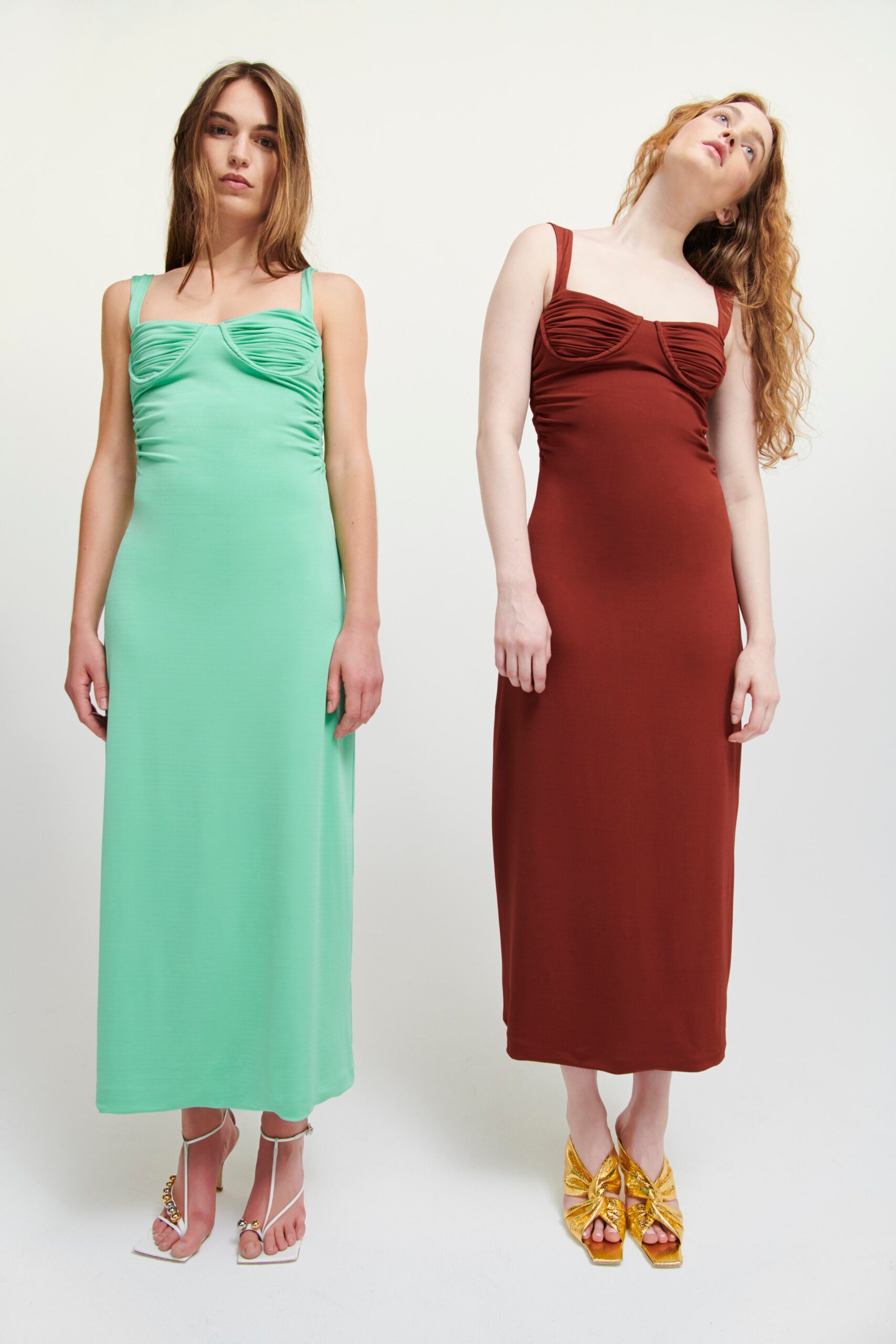Two fitted dresses in green and brown, featuring sleeveless designs and ruched detailing.