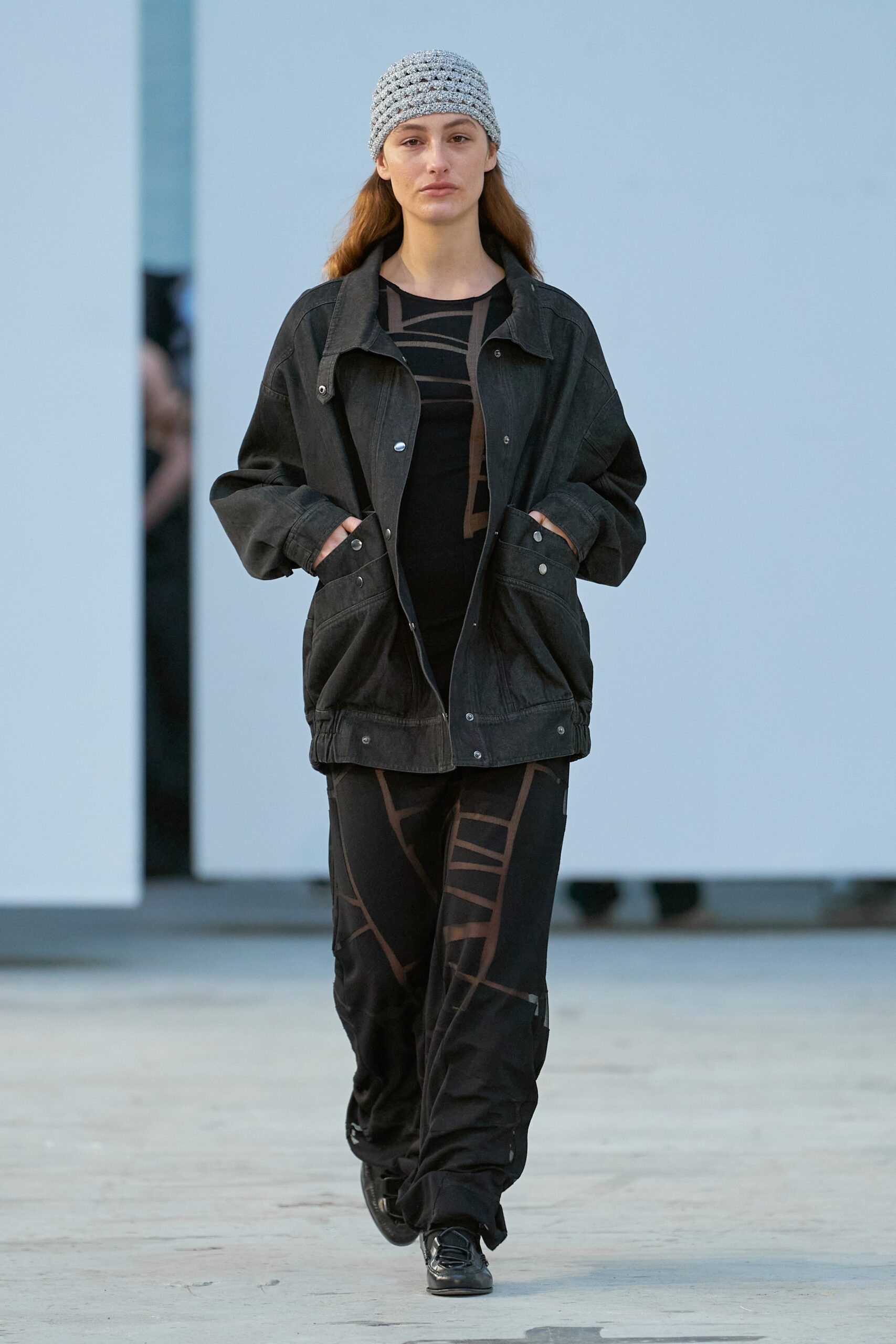 A relaxed black denim jacket with long sleeves paired with matching relaxed pants.