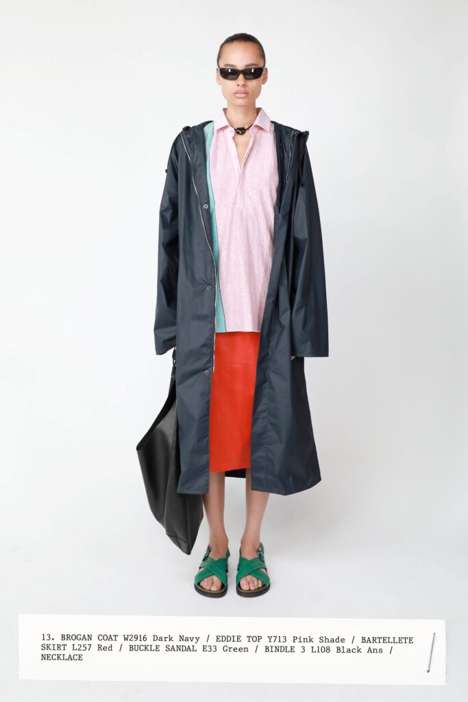 A relaxed dark navy coat paired with a red skirt, featuring a long-sleeve collared design.