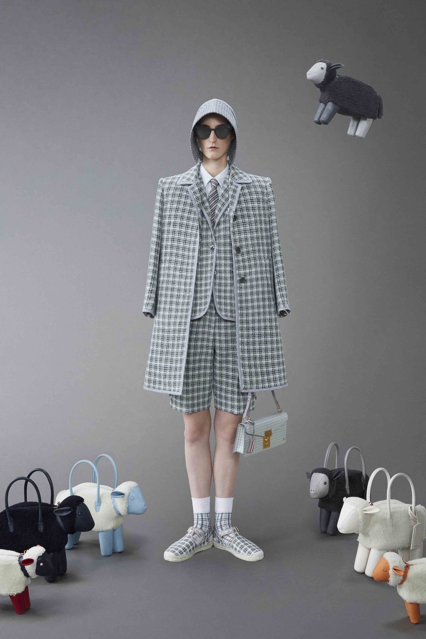 A relaxed gray checked coat paired with matching shorts and a collared shirt.