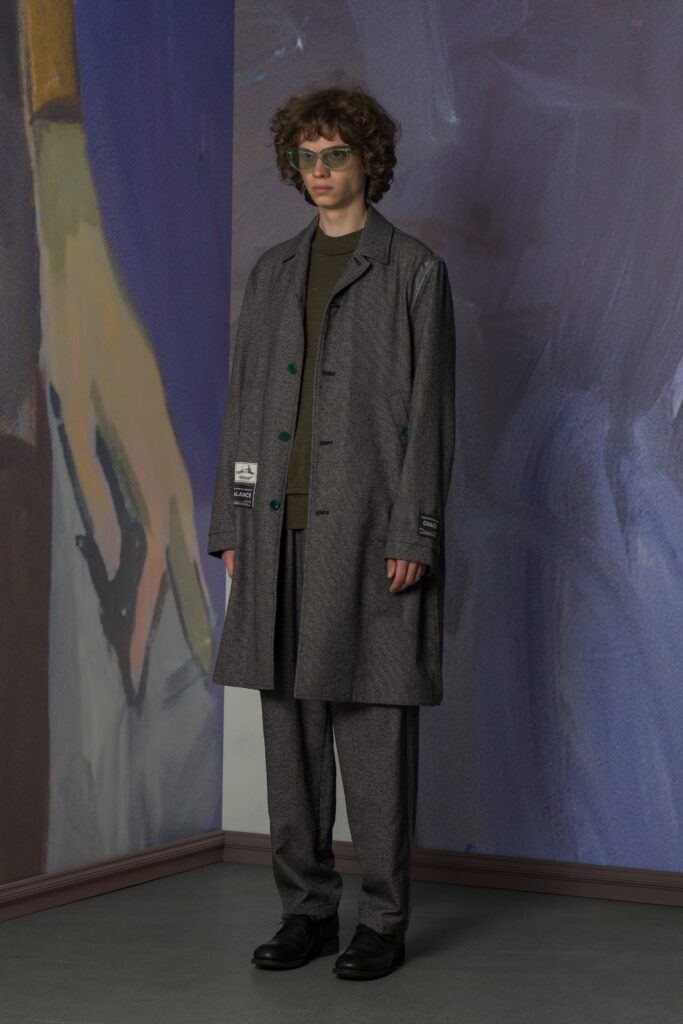 A relaxed gray wool coat with a collared neckline paired with straight-leg pants.