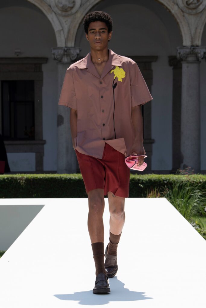 A relaxed brown cotton short-sleeve shirt with a collar paired with red shorts.