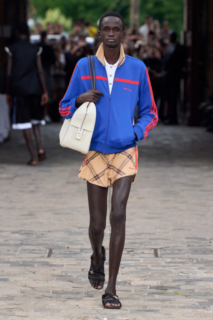 A relaxed blue long-sleeve jacket with stripes paired with plaid beige shorts.