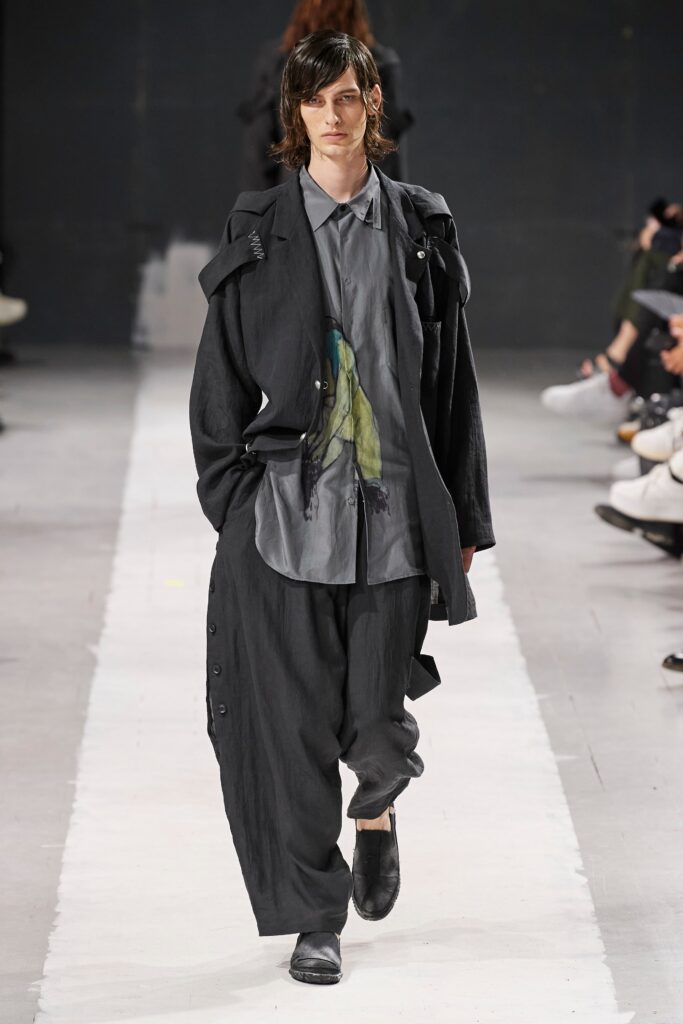 A relaxed black jacket with long sleeves and a collared shirt paired with wide-leg pants.