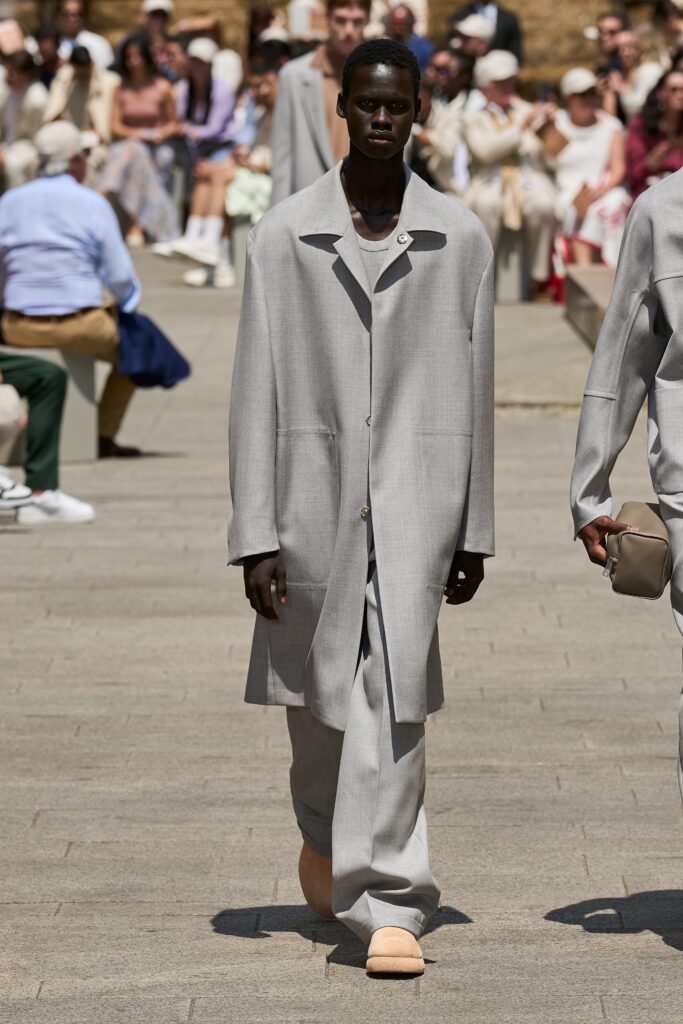A relaxed gray coat with long sleeves and a collared design, paired with straight-leg pants.