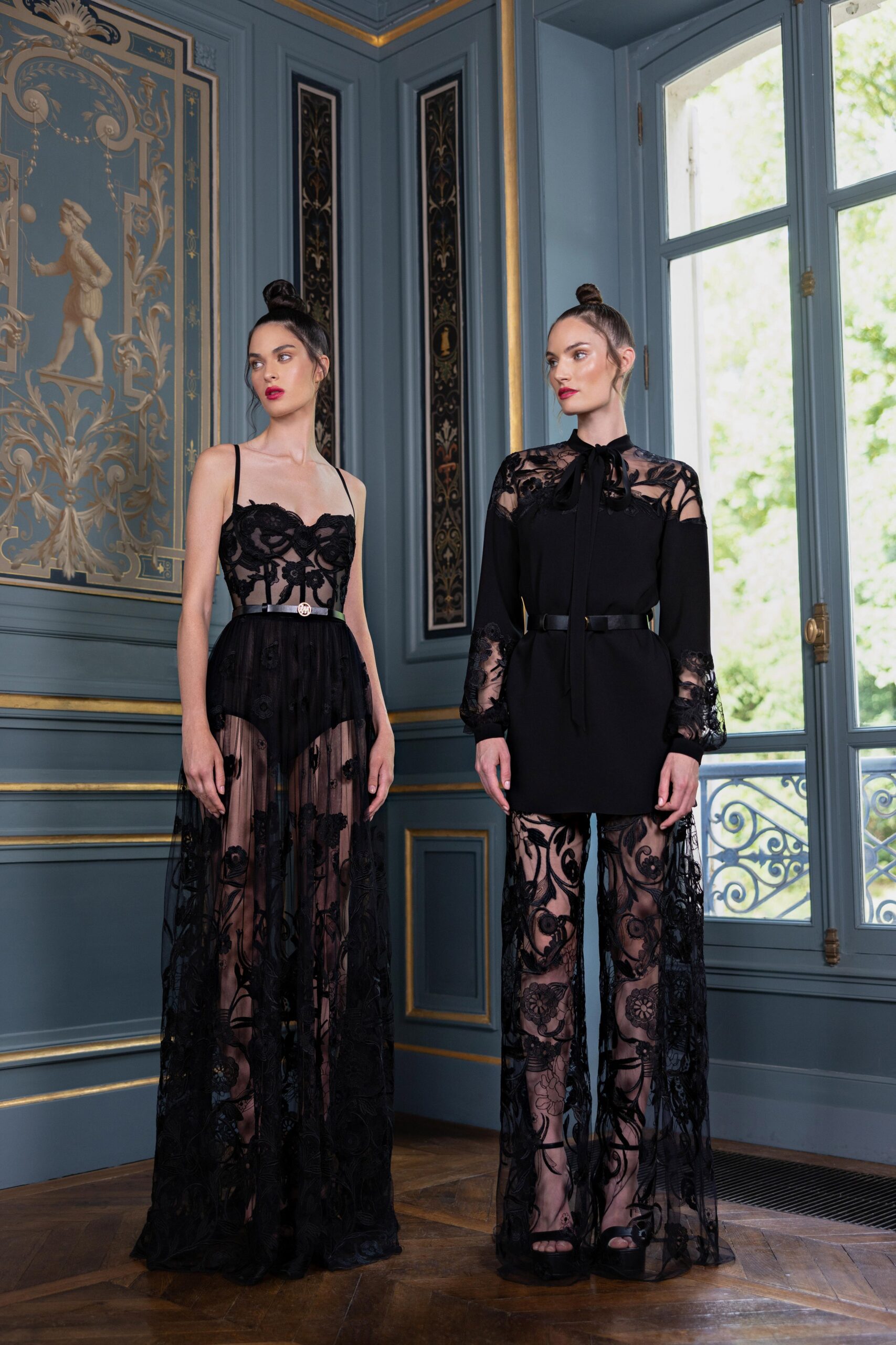A fitted black lace dress with a sleeveless design and layered details.