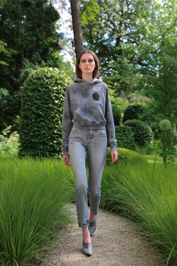 A fitted gray printed hoodie paired with fitted jeans for a casual look.