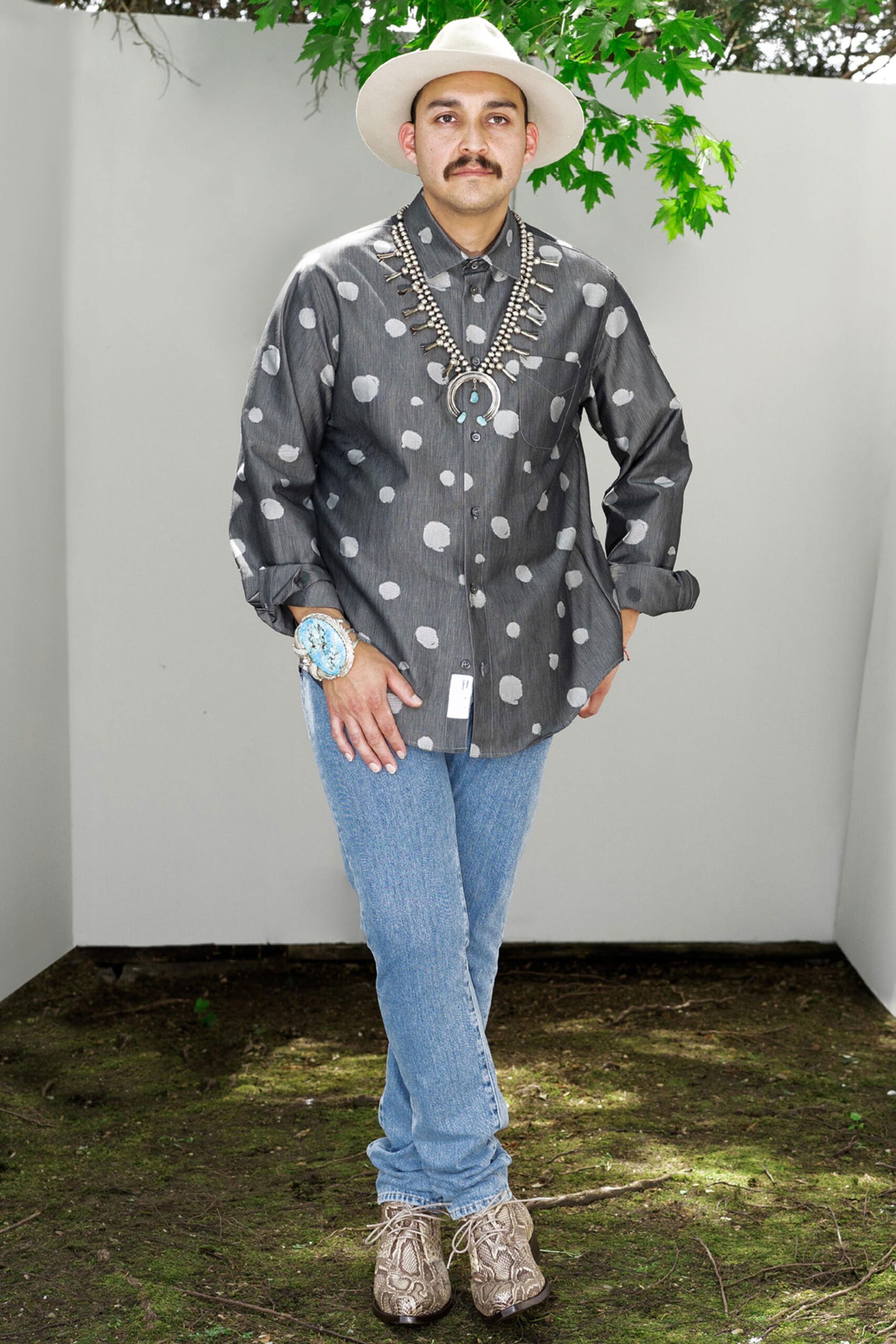 A relaxed-fit gray polka-dot shirt paired with blue jeans, featuring a long-sleeve and collared design.