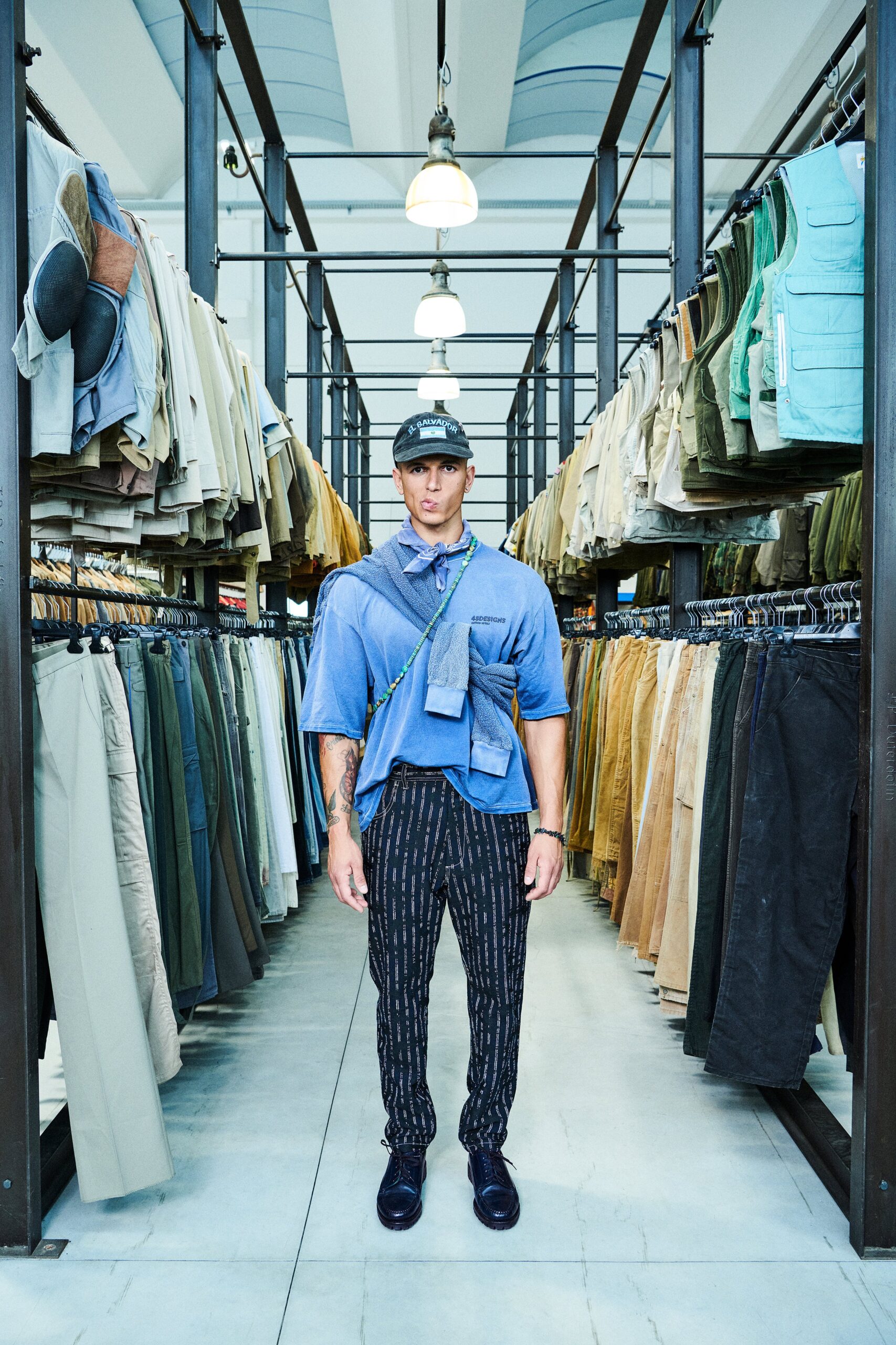 A fitted blue collared shirt paired with black striped pants, creating a stylish look.