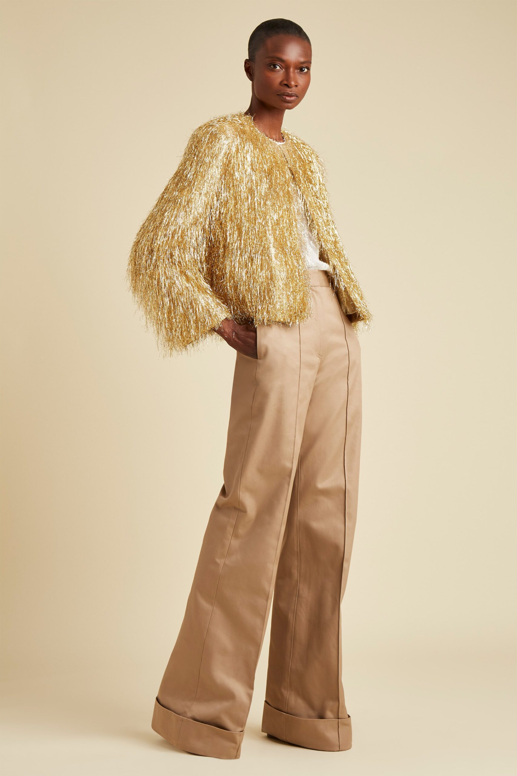 gold fringed jacket with beige pants
