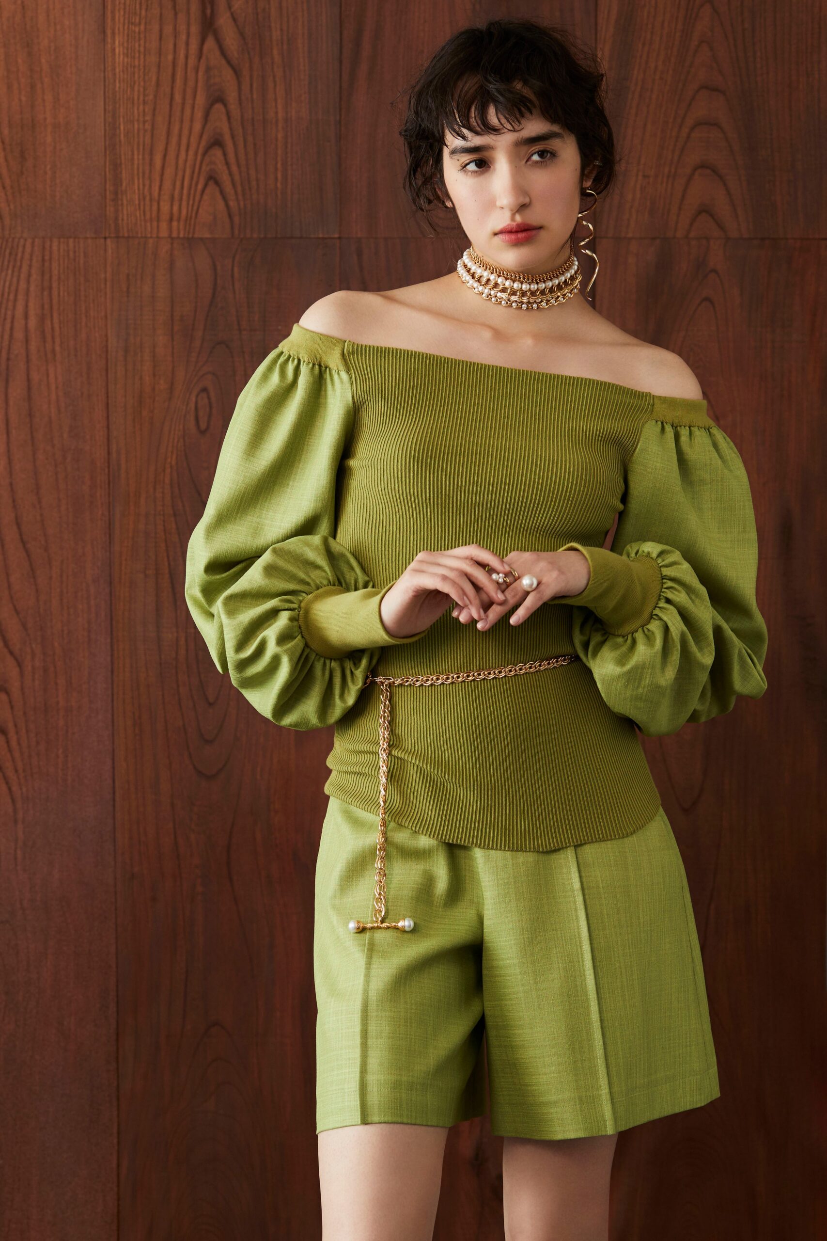 green off-shoulder top with pleated shorts