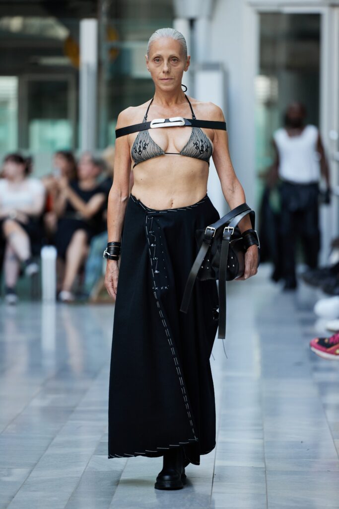 An asymmetric black skirt paired with a sleeveless top, showcasing a bold and edgy style.