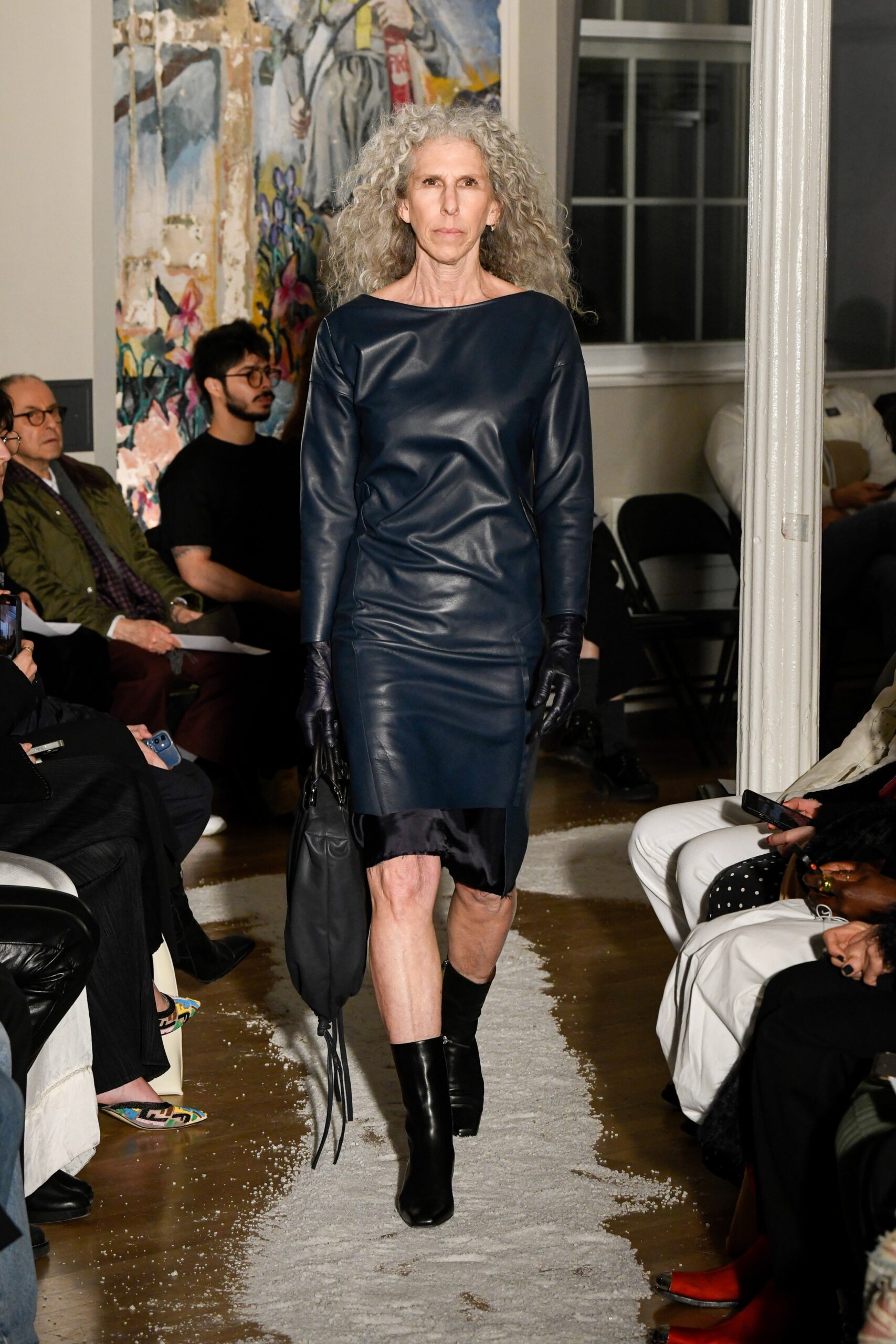 A fitted black leather dress with long sleeves and a high neckline, showcasing a sleek silhouette.