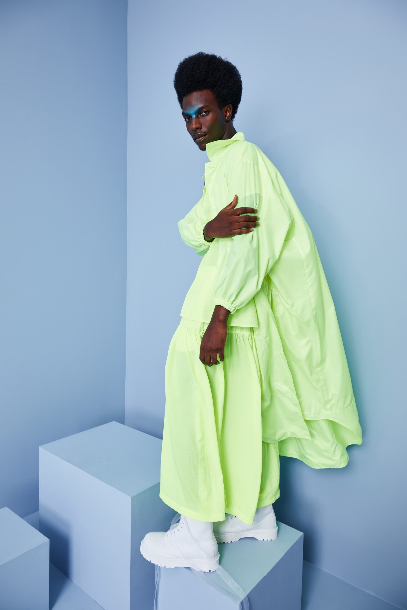 This oversized dress jacket in a vibrant green hue features a unique layered design that adds depth and movement. The long sleeves and collared neckline contribute to its relaxed silhouette, while the asymmetric elements create a striking visual interest.