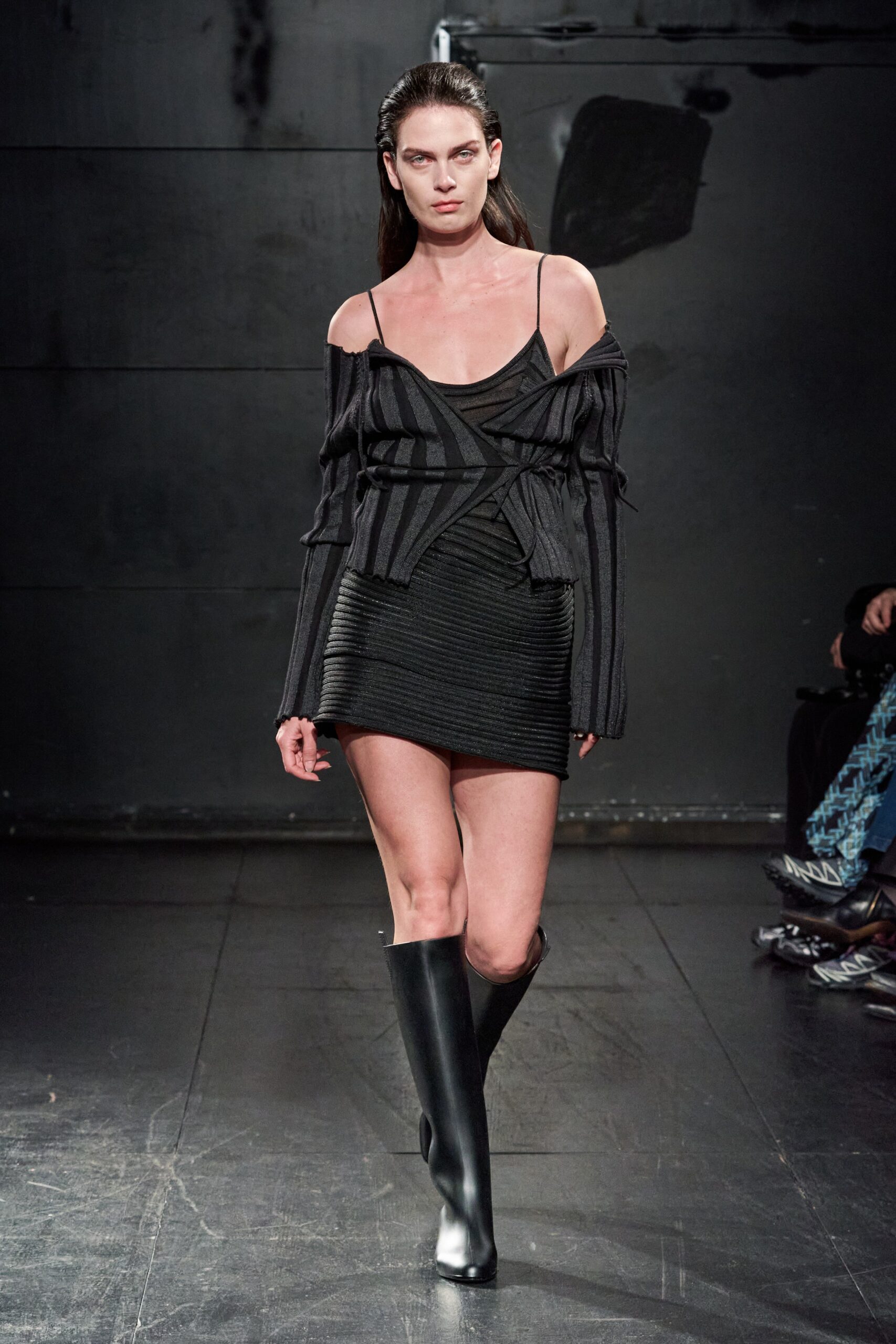A fitted black dress paired with a stylish jacket featuring an asymmetric design.