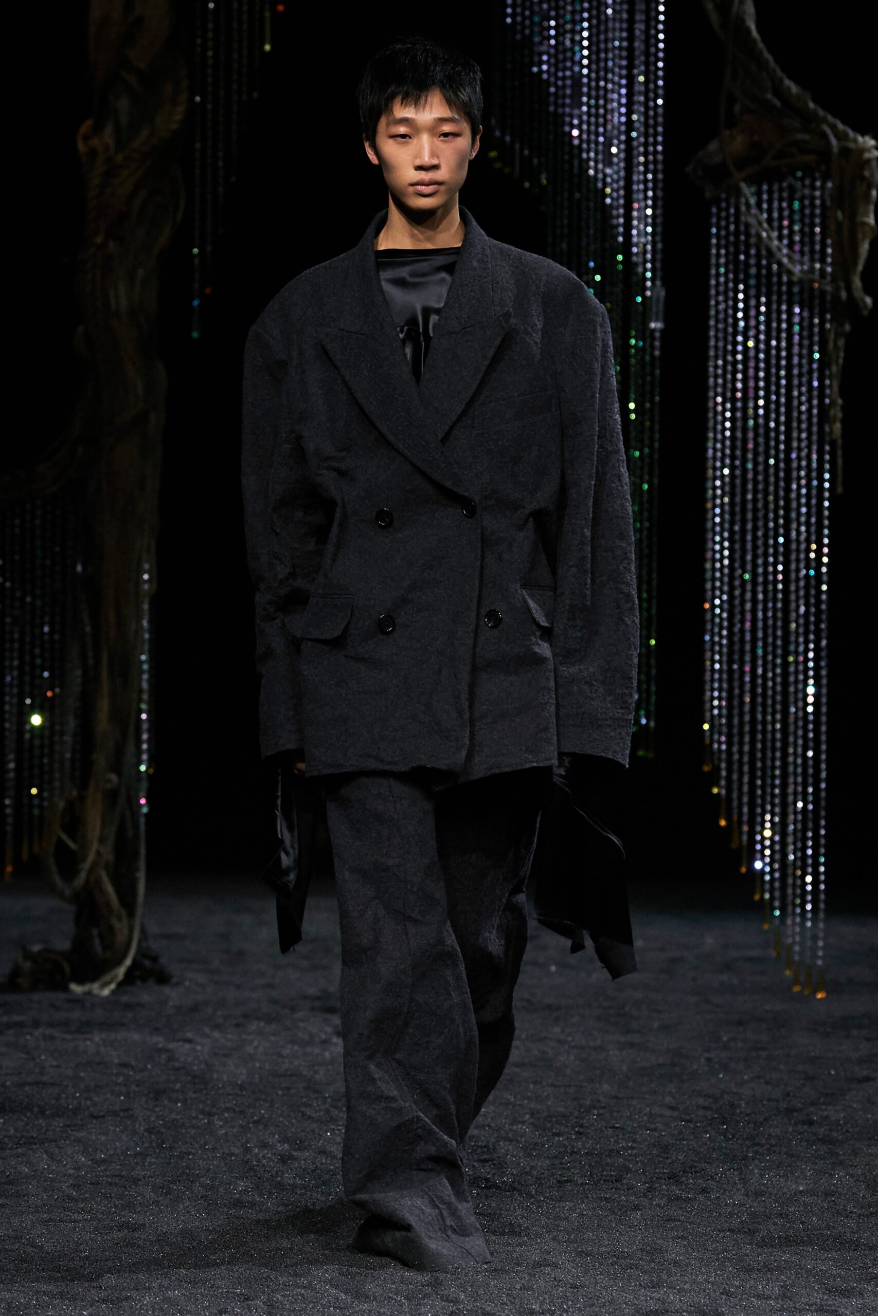 An oversized black wool jacket with long sleeves and a double-breasted design.