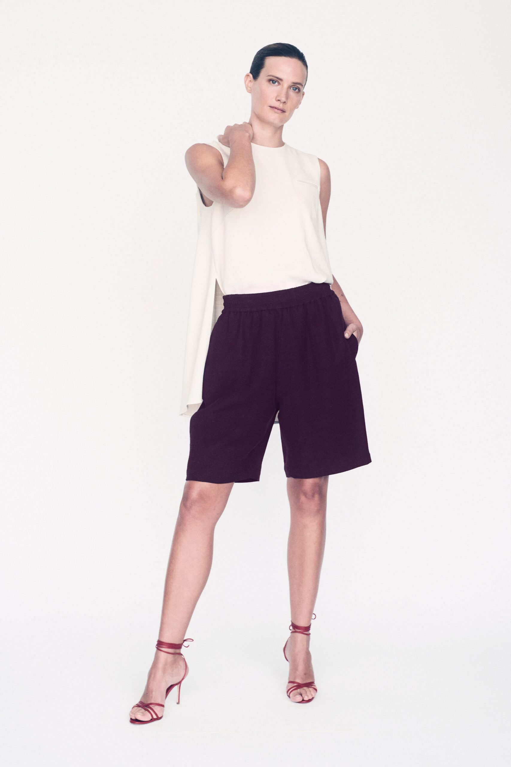 white relaxed top with purple shorts
