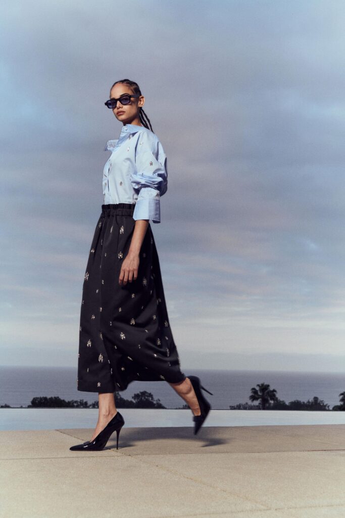 A relaxed blue collared shirt paired with a black printed skirt for a chic look.