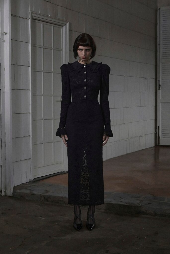 A fitted black lace dress with long sleeves and a pencil silhouette.