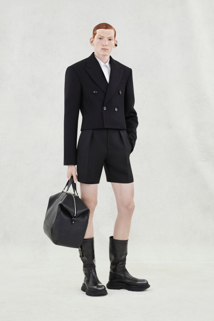 A fitted black blazer with long sleeves and a collared neckline paired with tailored shorts.