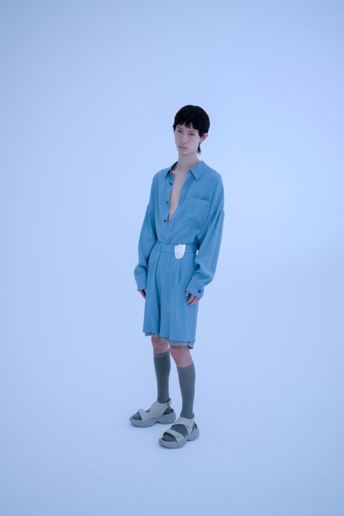 A relaxed blue cotton dress with long sleeves and a collared neckline, featuring button details.