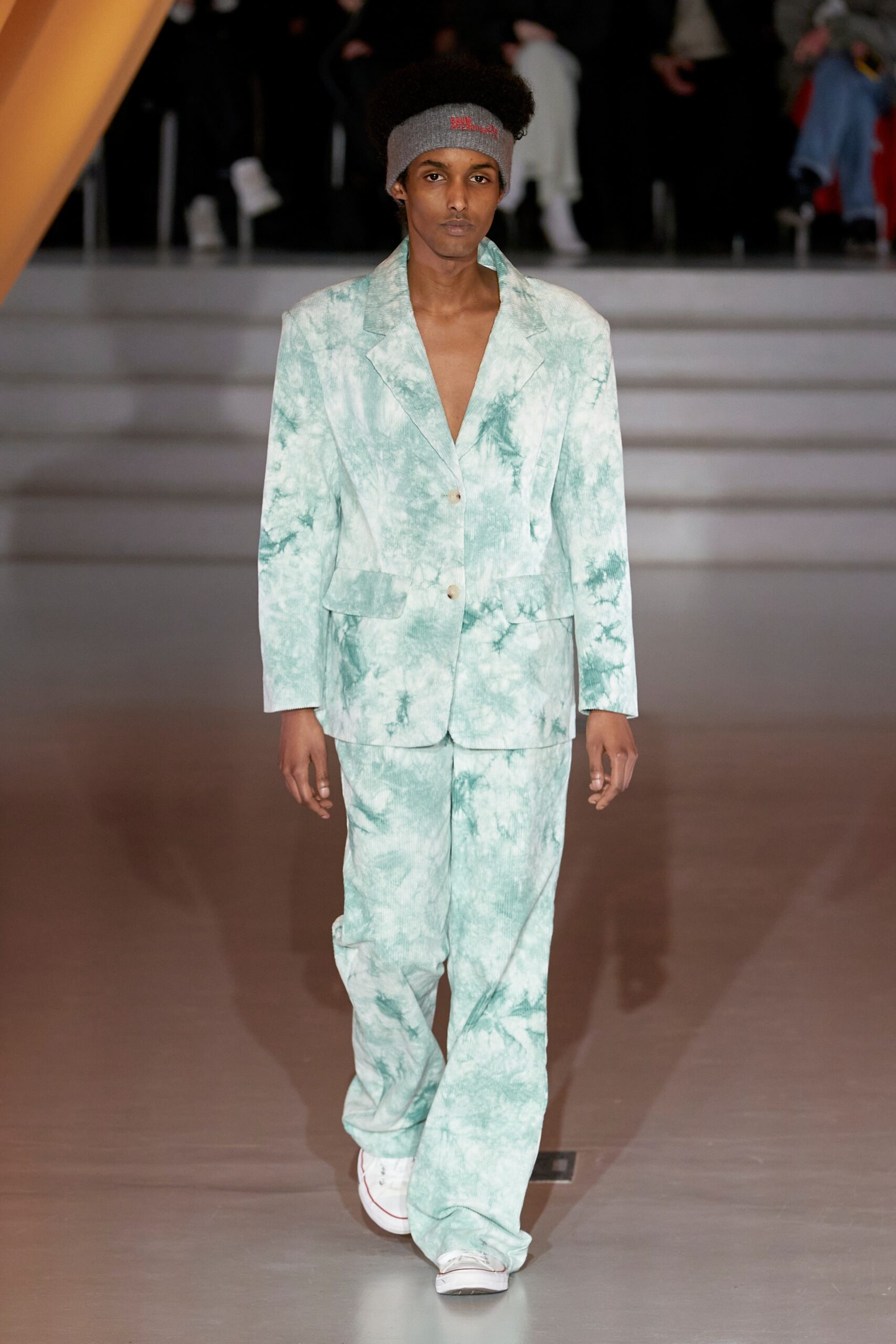 A fitted green cotton suit with a collared long-sleeve design and printed texture.