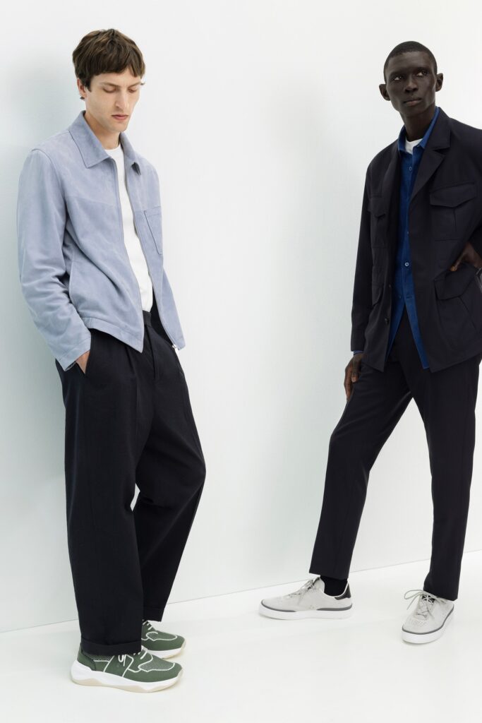 A relaxed blue cotton jacket with long sleeves and a collared design, paired with black straight-leg pants.