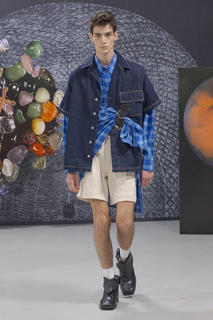 A relaxed blue denim jacket paired with white checked shorts, featuring a layered design.