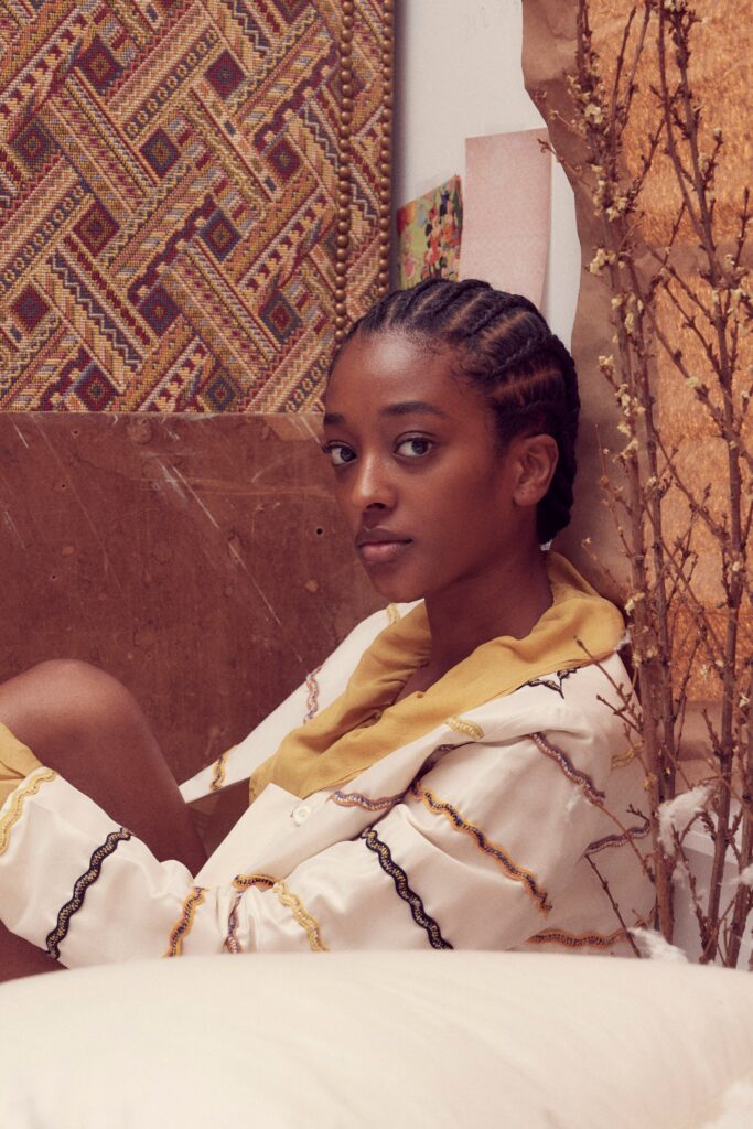 A relaxed white shirt with long sleeves, a collar, and a printed design in yellow accents.