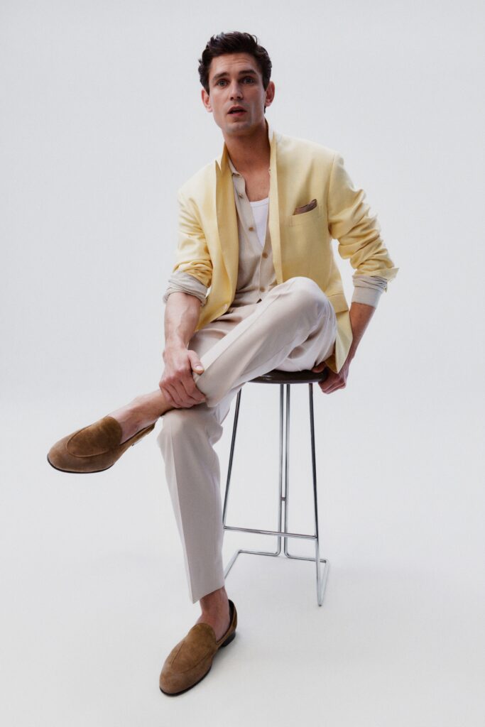 A tailored yellow cotton blazer paired with beige pants and a stylish look.