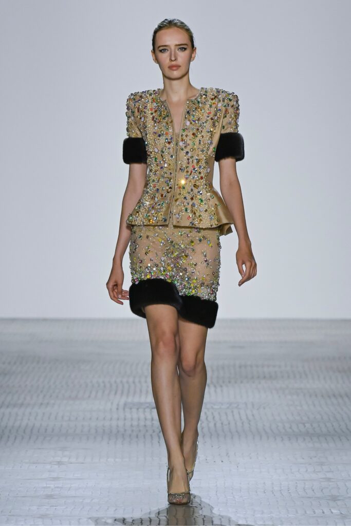 A fitted beige silk dress with short sleeves, a V-neckline, and intricate embroidery.