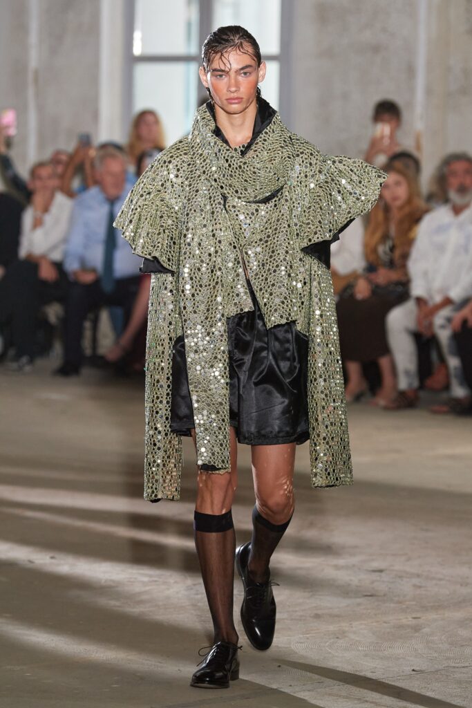 green sequin cape and black shorts