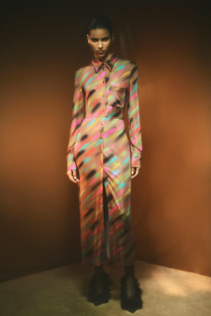 A fitted multicolor silk dress with long sleeves, a collared neckline, and a buttoned front with a slit.