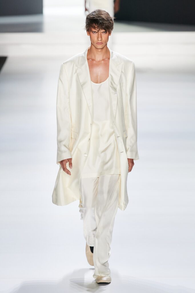 A relaxed white silk suit featuring a V-neck and layered design elements.