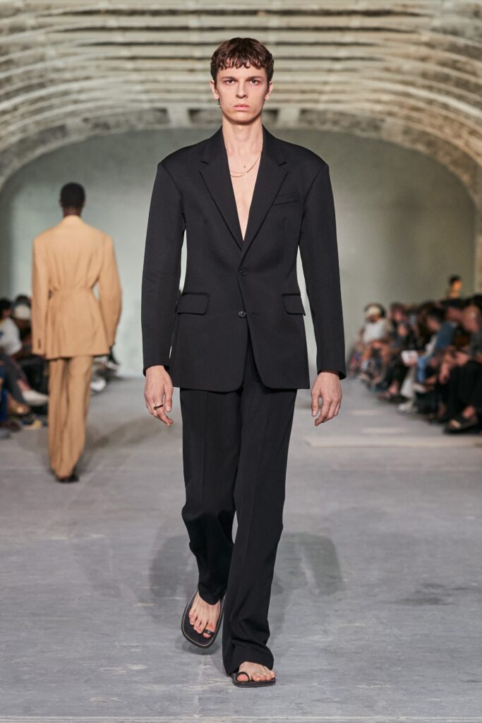 A tailored black suit featuring a collared long-sleeve jacket and straight-leg trousers.