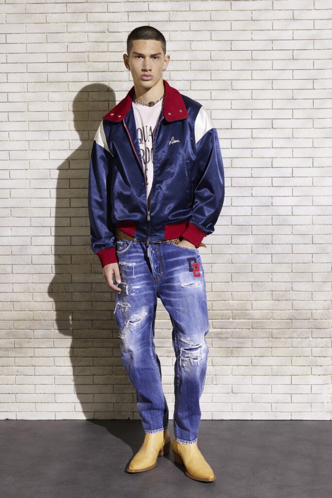An oversized blue jacket paired with distressed blue jeans and stylish boots.