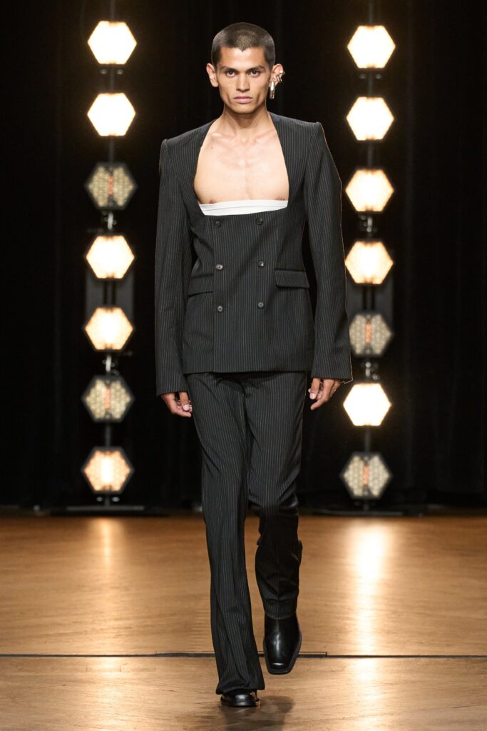 A fitted black striped suit with long sleeves and a collared design.