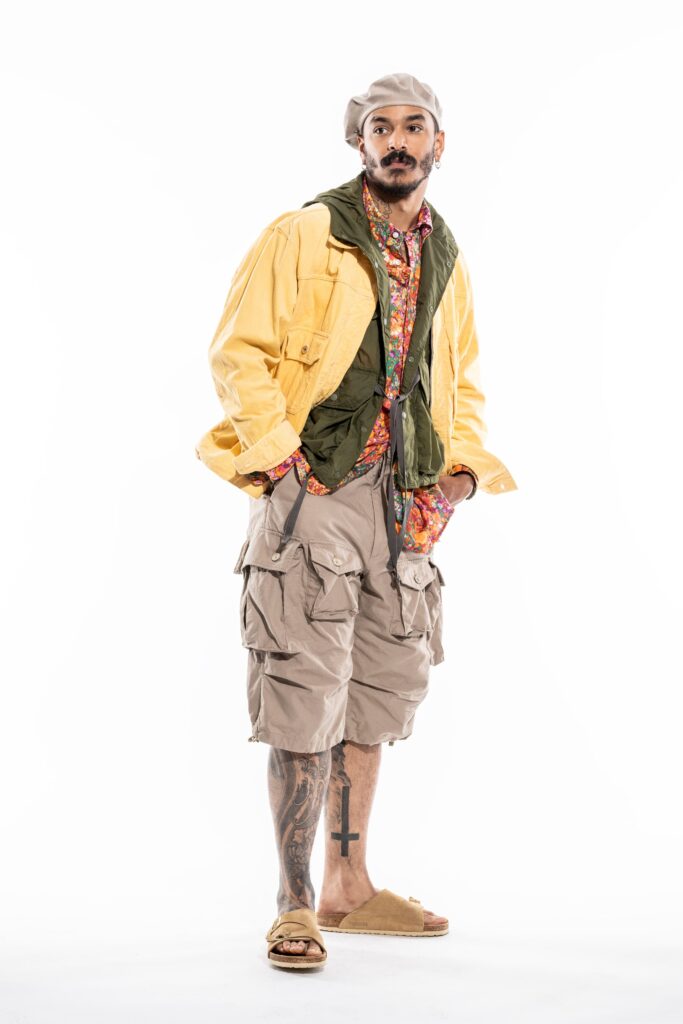 A relaxed yellow cotton jacket with long sleeves paired with beige shorts.