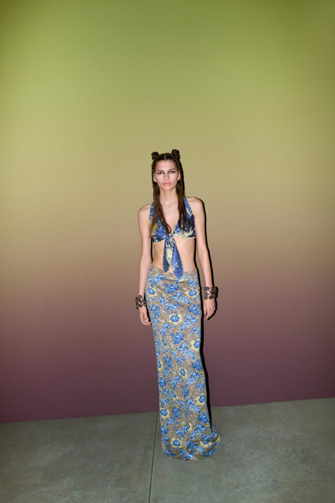 A fitted blue silk sleeveless dress with a V-neckline and flared silhouette.