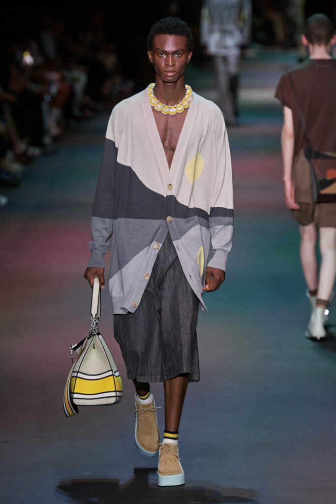 A relaxed gray cardigan with long sleeves and a collared design paired with an asymmetric denim skirt.