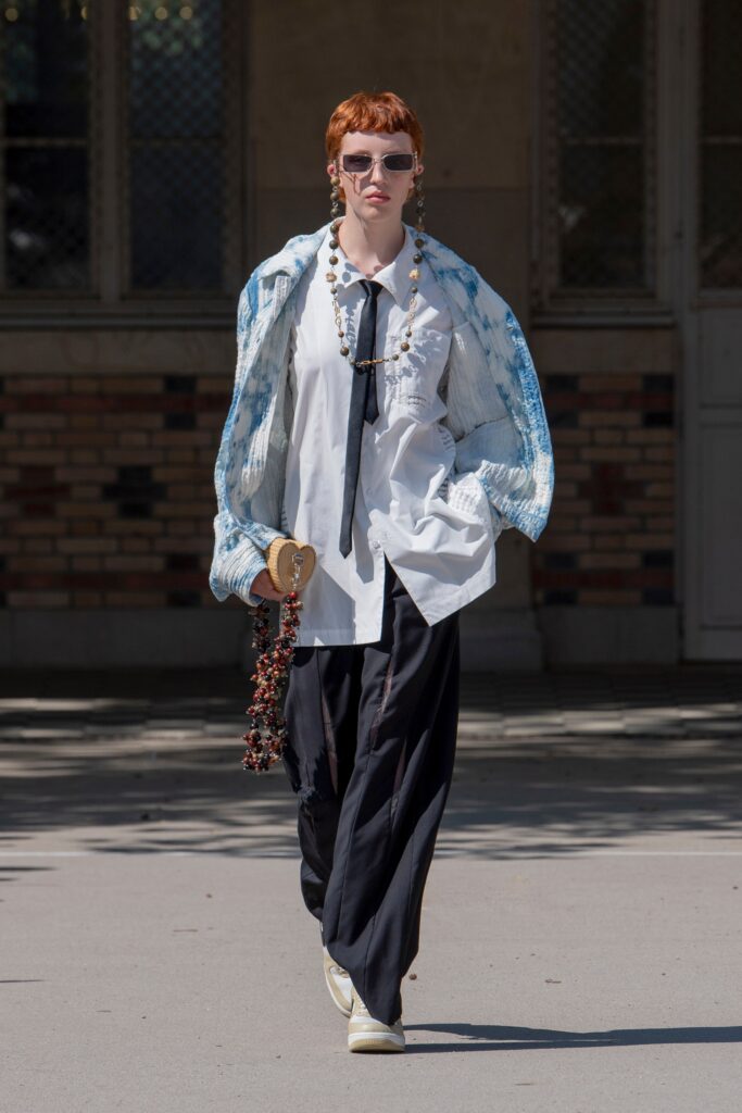 A relaxed white collared shirt paired with wide-leg black pants.