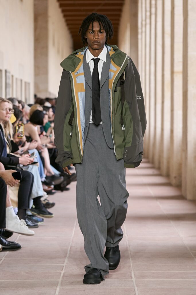 A relaxed fit green jacket with a collared neckline paired with wide-leg gray pants.