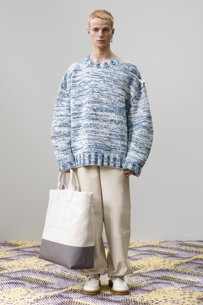 An oversized blue and white striped sweater paired with relaxed pants.