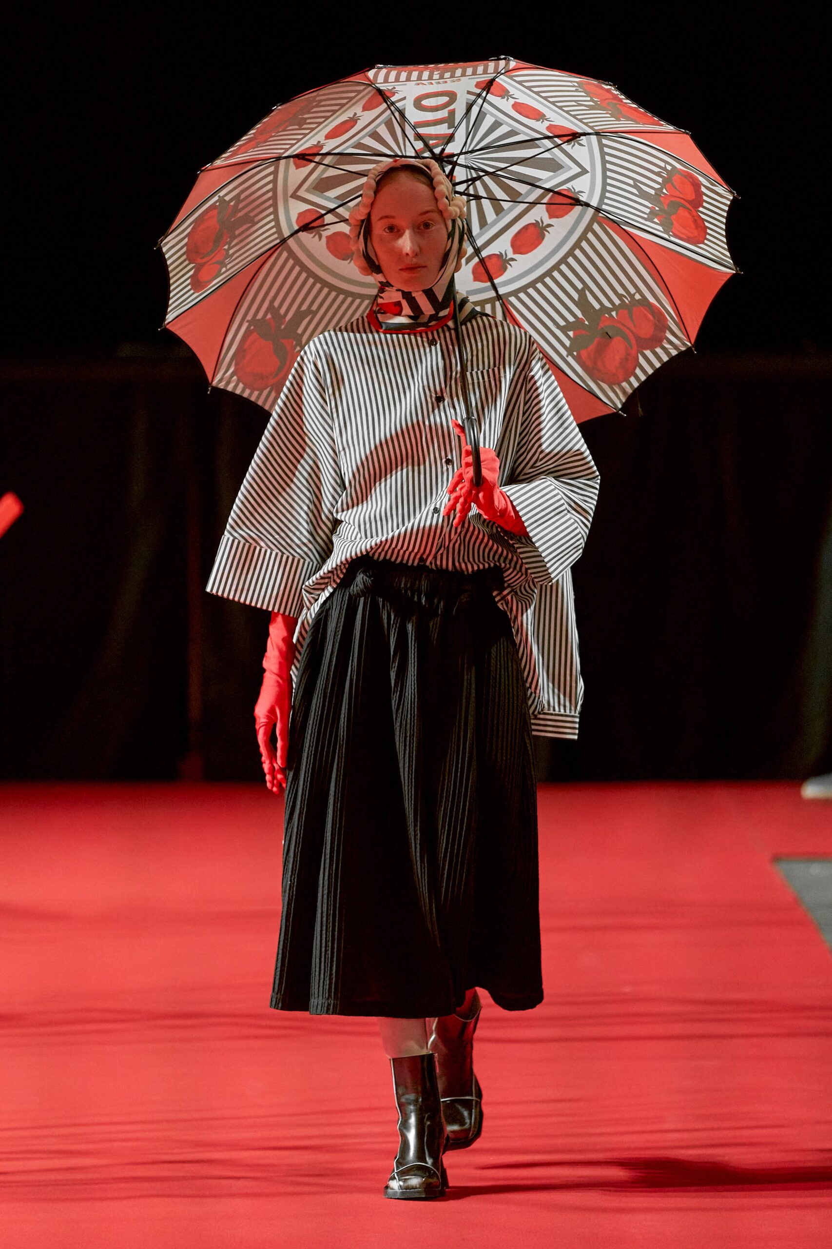 A relaxed black and white striped top with a collared neckline paired with a pleated black skirt.