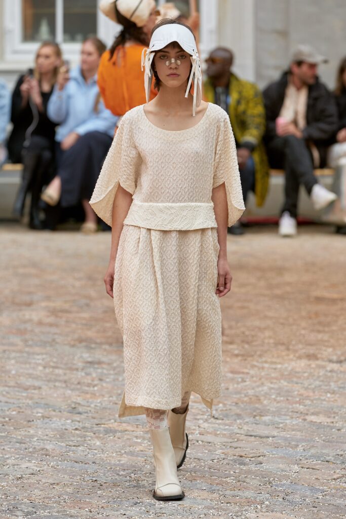 A relaxed beige cotton dress with short sleeves and a tiered design.
