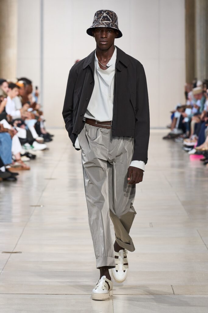 A relaxed black jacket paired with gray straight-leg pants for a modern look.