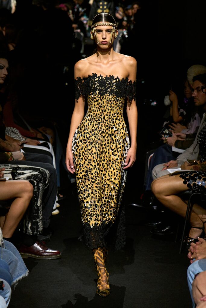 A fitted off-shoulder dress featuring a black and yellow animal-print design.
