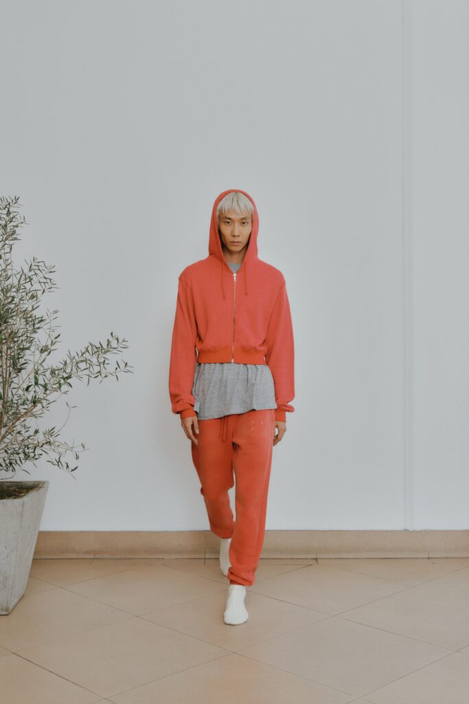 A relaxed red cotton hoodie with long sleeves and matching pants, featuring a zippered detail.